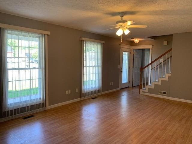 foyer featuring ceiling fan, wood-type flooring, and a textured ceiling