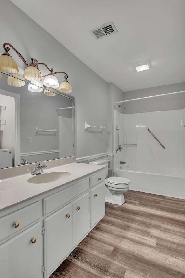 full bathroom featuring shower / washtub combination, vanity, wood-type flooring, and toilet