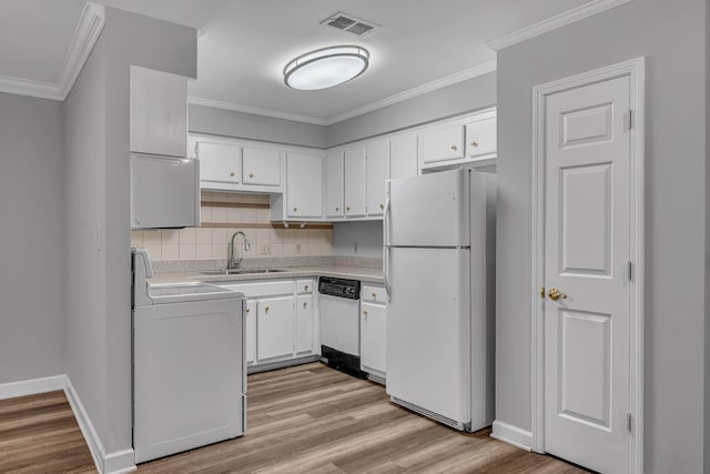 kitchen with light hardwood / wood-style floors, white appliances, sink, white cabinets, and washer / clothes dryer