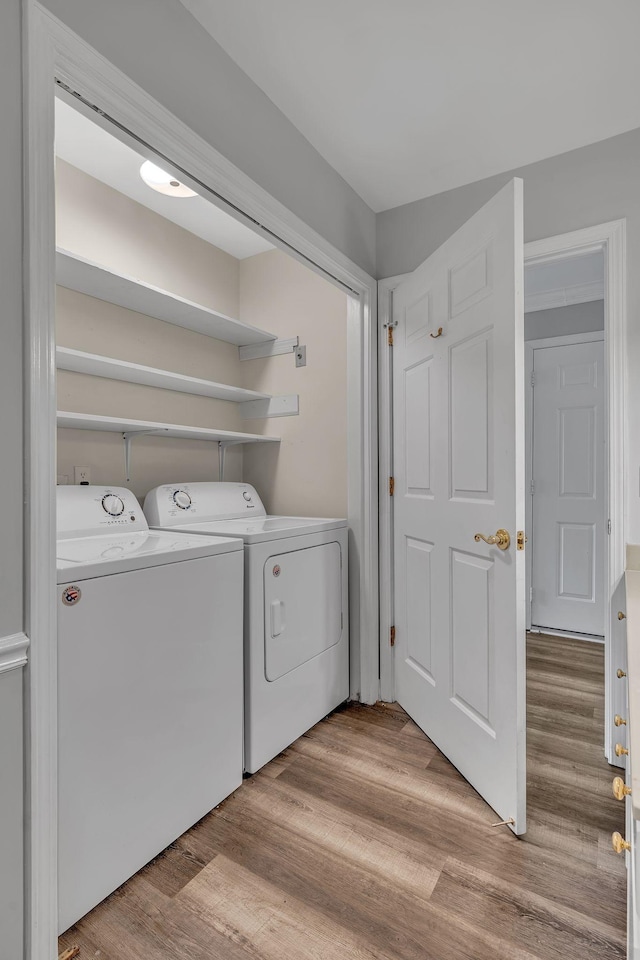 laundry room featuring light wood-type flooring and washer and clothes dryer