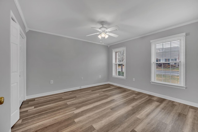 empty room featuring hardwood / wood-style flooring, ceiling fan, and ornamental molding