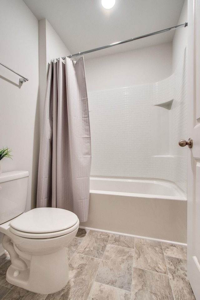 bathroom featuring shower / bath combination with curtain and toilet