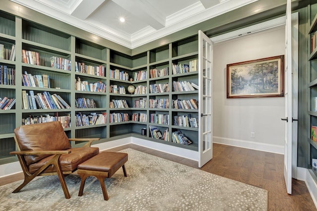 sitting room with beam ceiling, built in features, hardwood / wood-style floors, and ornamental molding