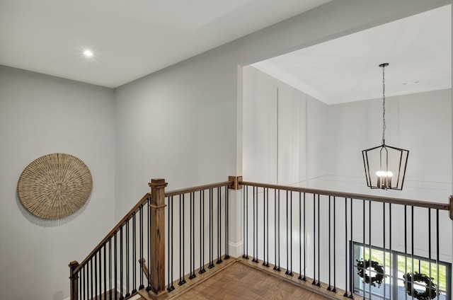 hall with hardwood / wood-style floors and a notable chandelier