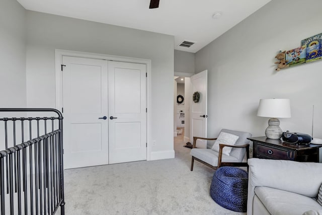 carpeted bedroom featuring ceiling fan and a closet