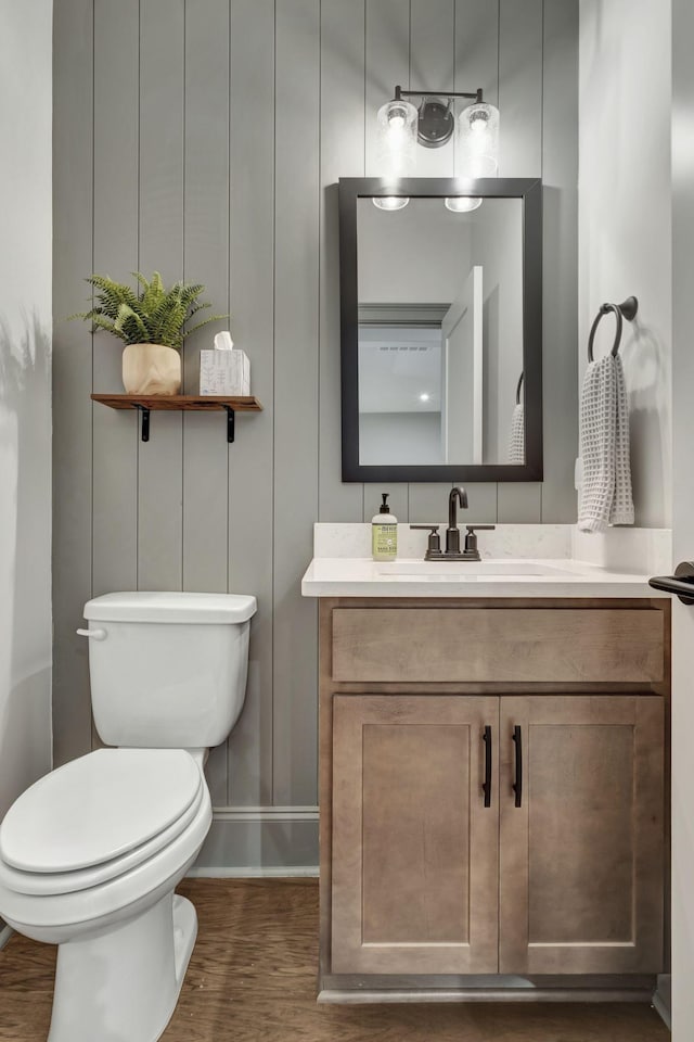 bathroom with hardwood / wood-style floors, vanity, and toilet