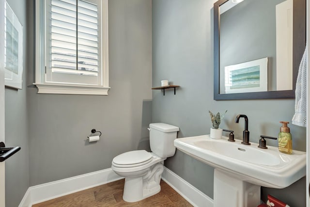 bathroom with hardwood / wood-style flooring, toilet, and sink