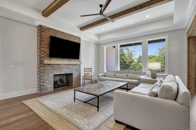 living room featuring a fireplace, hardwood / wood-style floors, ceiling fan, and beam ceiling