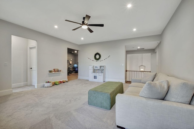 carpeted living room with ceiling fan with notable chandelier