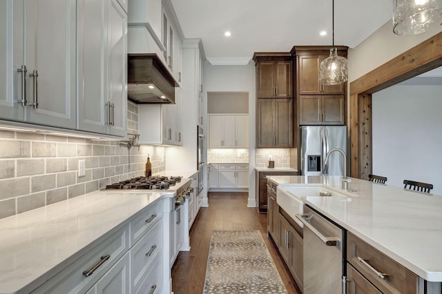 kitchen with sink, decorative light fixtures, decorative backsplash, a center island with sink, and appliances with stainless steel finishes