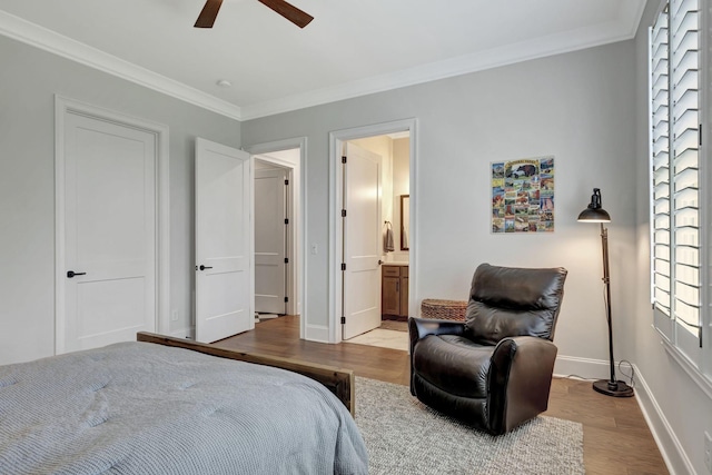 bedroom featuring hardwood / wood-style flooring, ensuite bath, ceiling fan, and ornamental molding