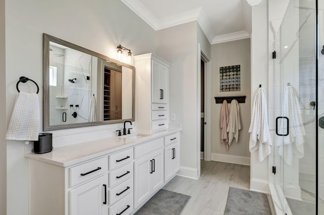 bathroom with hardwood / wood-style flooring, vanity, ornamental molding, and walk in shower