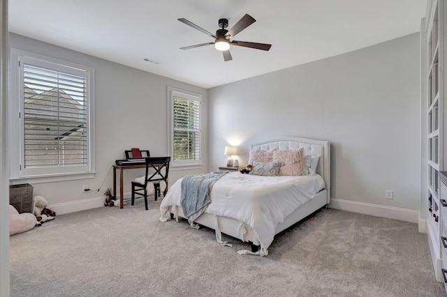 carpeted bedroom with multiple windows and ceiling fan