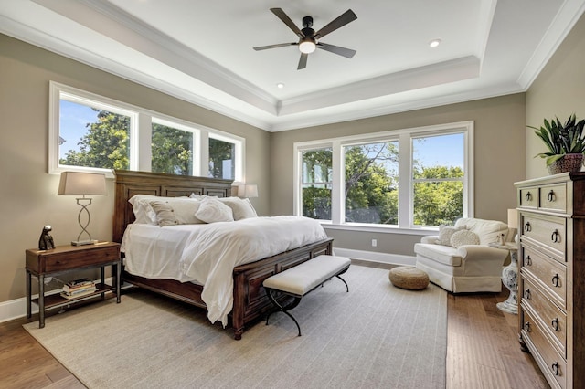 bedroom featuring a raised ceiling, ceiling fan, hardwood / wood-style floors, and crown molding