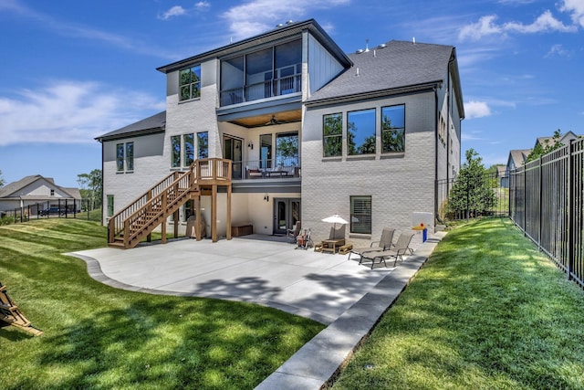 rear view of property with a yard, a patio, a balcony, and ceiling fan