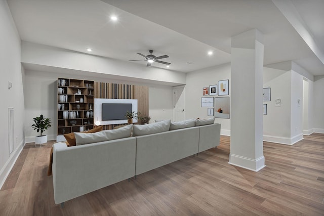 living room featuring ceiling fan and light wood-type flooring