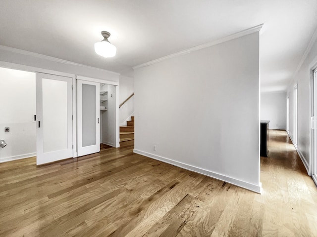 spare room with wood-type flooring and crown molding