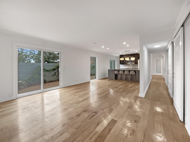 unfurnished living room featuring light hardwood / wood-style flooring and sink