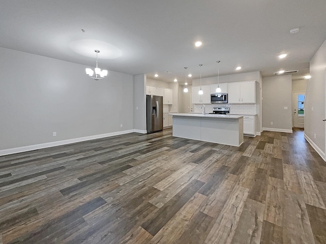 kitchen with a kitchen island with sink, white cabinets, hanging light fixtures, and appliances with stainless steel finishes