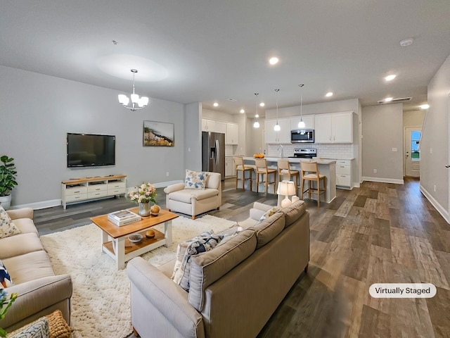 living room with a chandelier and dark wood-type flooring