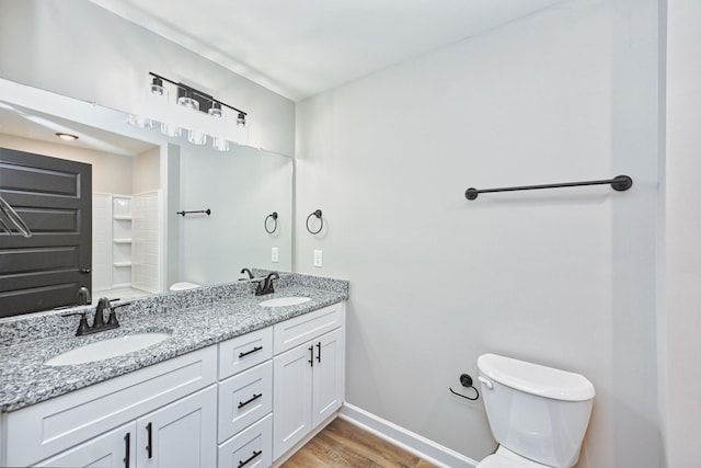 bathroom with vanity, toilet, wood-type flooring, and walk in shower