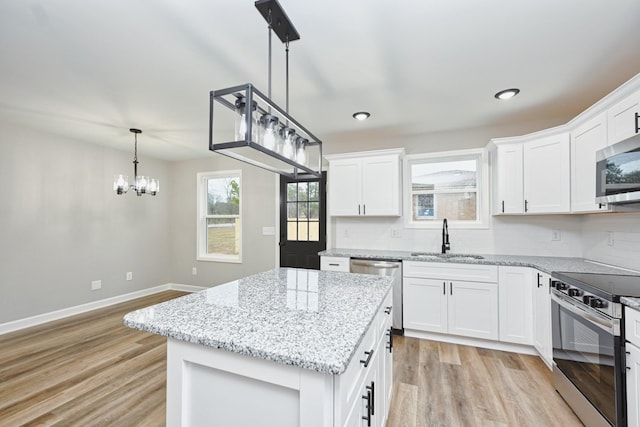 kitchen featuring white cabinets, sink, light hardwood / wood-style flooring, appliances with stainless steel finishes, and a kitchen island