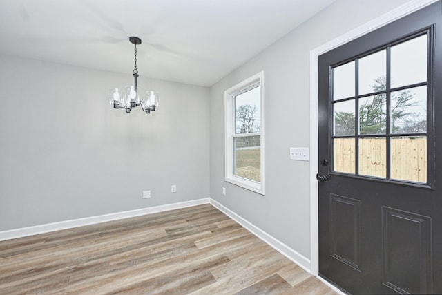 interior space with plenty of natural light, a chandelier, and light wood-type flooring