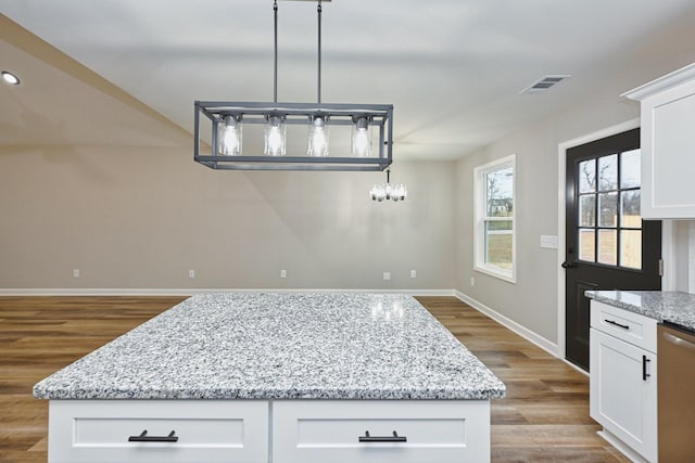 kitchen featuring white cabinets, dishwasher, a kitchen island, and hardwood / wood-style flooring