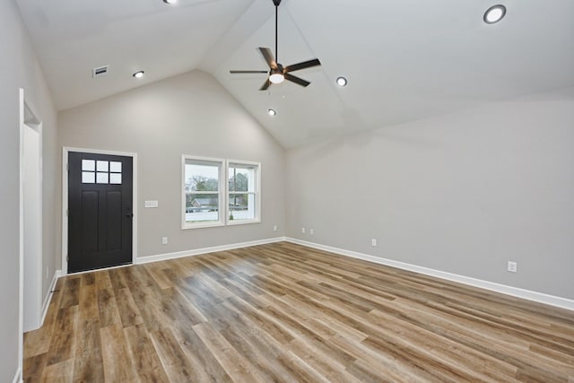 unfurnished living room featuring ceiling fan, high vaulted ceiling, and light wood-type flooring