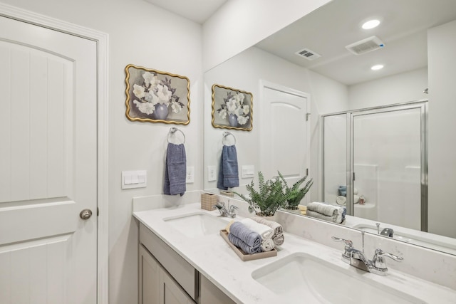 bathroom with a shower with door and vanity