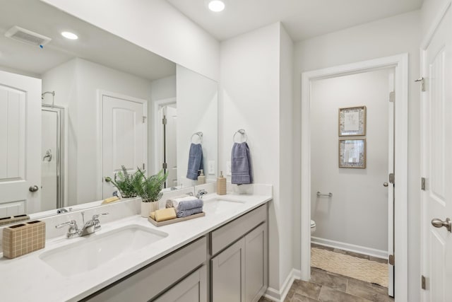 bathroom with toilet, vanity, and walk in shower