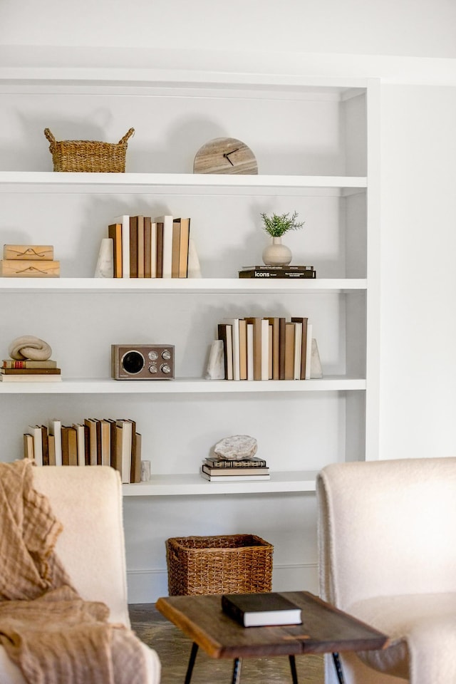 sitting room featuring built in shelves and wood finished floors