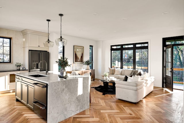 kitchen featuring a wealth of natural light, high quality fridge, a warming drawer, and a sink