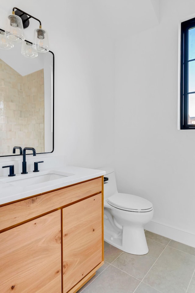 bathroom with tile patterned flooring, baseboards, vanity, and toilet