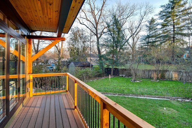 wooden deck featuring a shed and a lawn