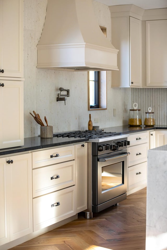 kitchen featuring white cabinets, tasteful backsplash, wall oven, parquet floors, and custom range hood