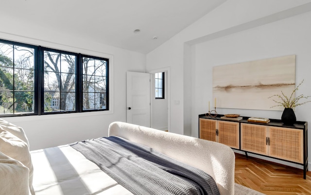 bedroom featuring lofted ceiling, parquet floors, and multiple windows