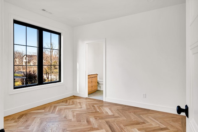 spare room featuring plenty of natural light and light parquet floors