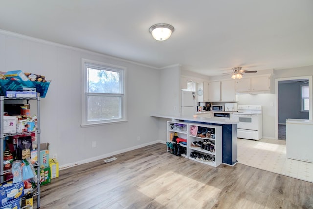 kitchen with kitchen peninsula, white appliances, ceiling fan, light hardwood / wood-style floors, and white cabinetry