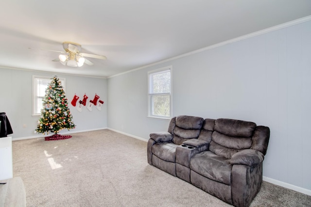 carpeted living room with ceiling fan, crown molding, and a wealth of natural light