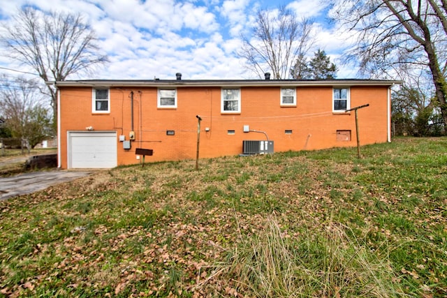 back of house with a lawn, a garage, and central AC