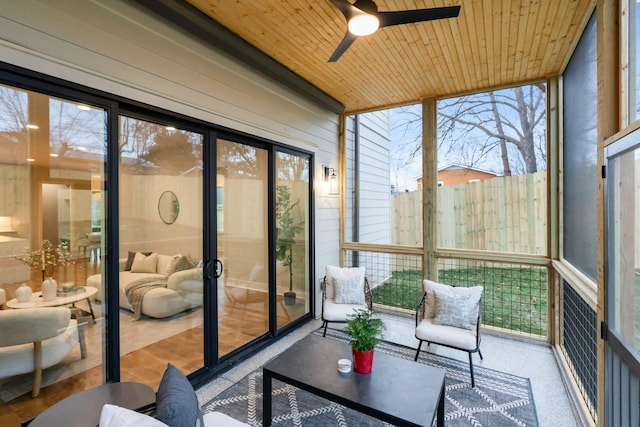 sunroom with ceiling fan, wooden ceiling, and a wealth of natural light