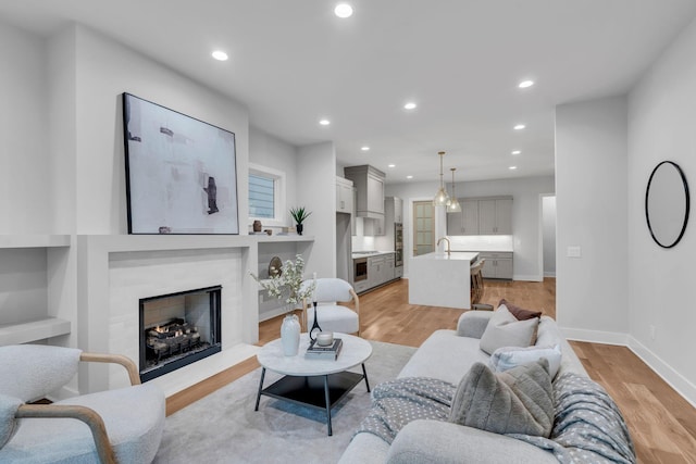 living room with sink and light wood-type flooring