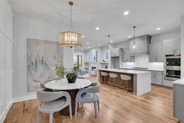 dining room with sink and light hardwood / wood-style floors