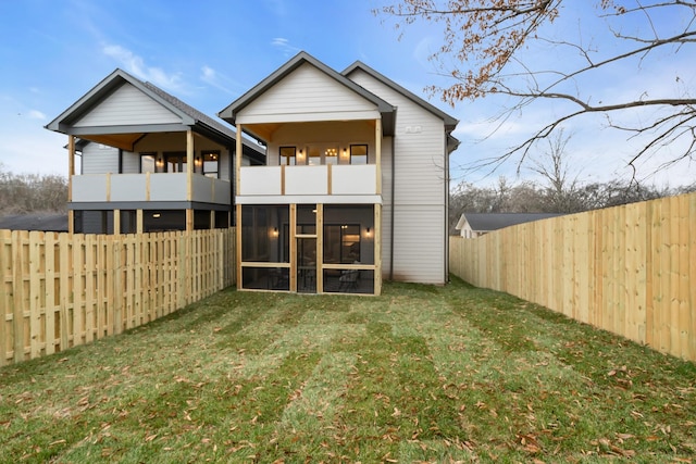 back of property featuring a balcony and a yard