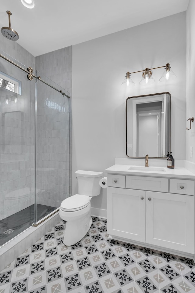 bathroom featuring vanity, a shower with shower door, and toilet