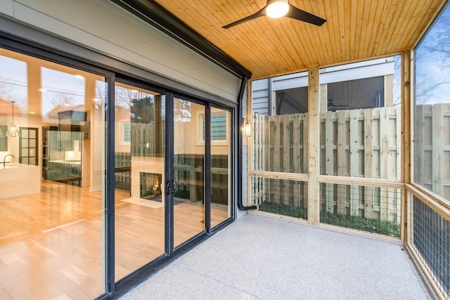 unfurnished sunroom with ceiling fan and wooden ceiling