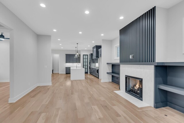 unfurnished living room with light hardwood / wood-style flooring and sink