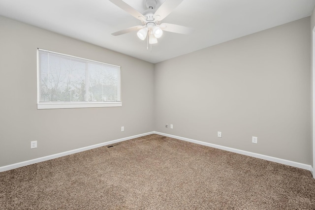 carpeted spare room featuring ceiling fan