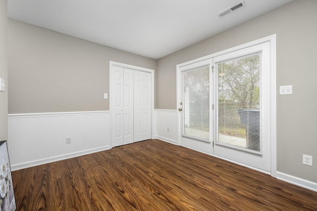 spare room with dark hardwood / wood-style flooring and a healthy amount of sunlight